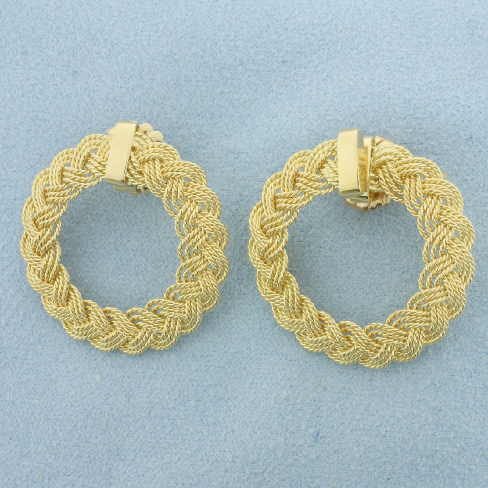 Braided Circle Earrings in 14k Yellow Gold: In 14k Yellow Gold. 1 1/8 inch diameter. Friction backs (oversized for comfort). 9.8g.
