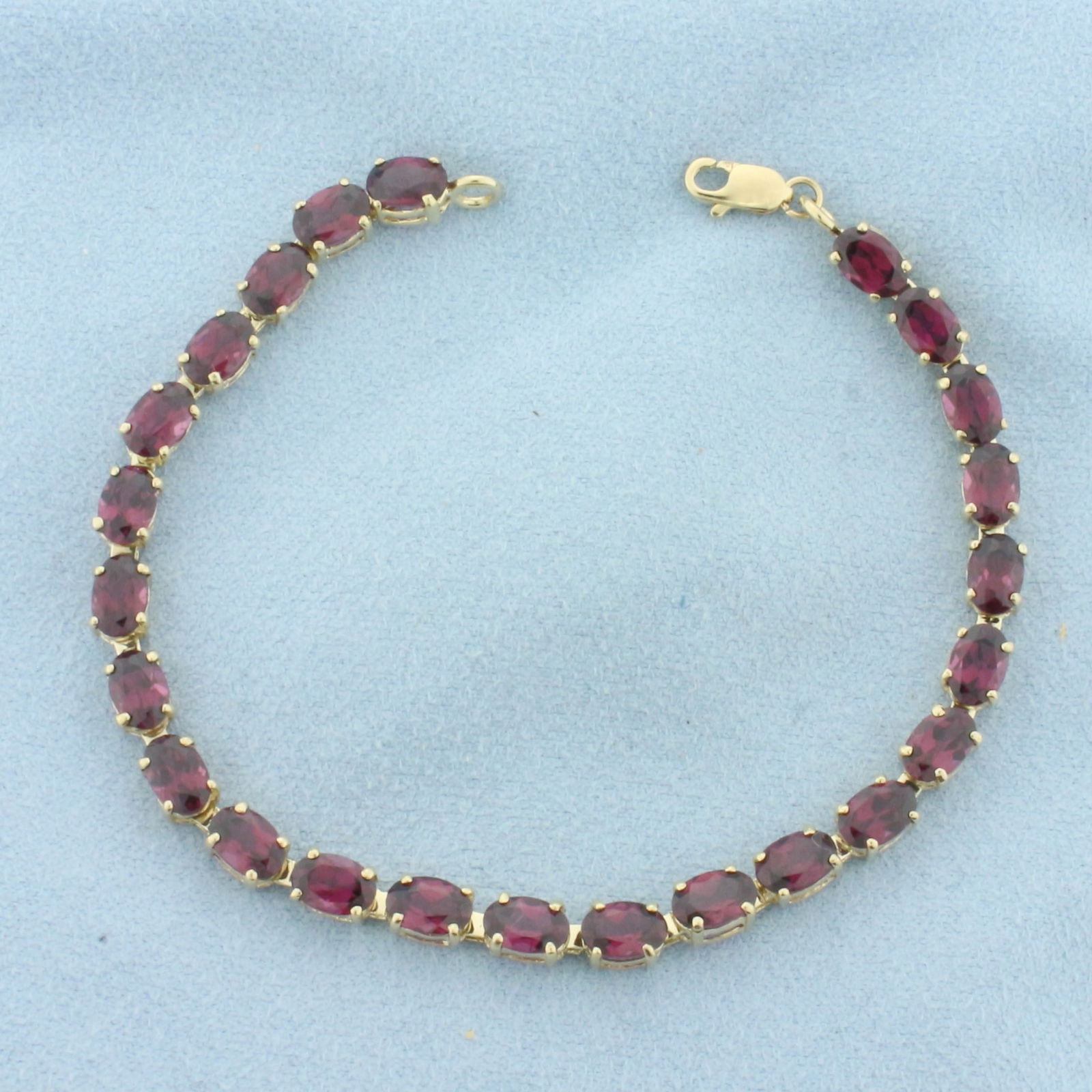 Garnet Tennis Bracelet in 10k Yellow Gold: In 10k Yellow Gold. Contains twenty-four 4x6mm high quality natural Garnet gemstones, approximately 12ct TW, with intense color and excellent clarity. 7 inches long. Lobster clasp. 7.0g.