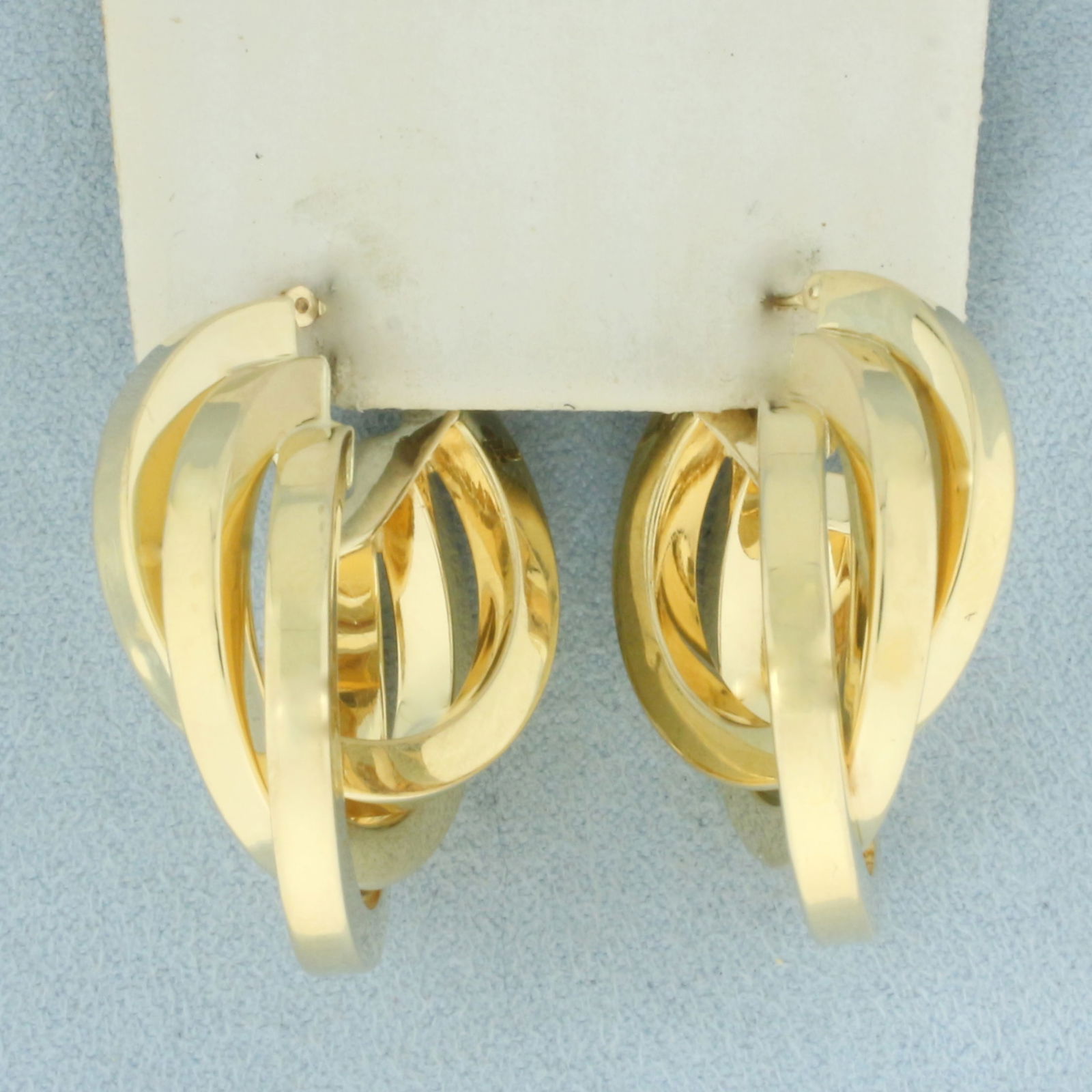 Designer Triple Hoop Earrings in 14k Yellow Gold: In 14k Yellow Gold. 1 1/4 inch long. 1 inch wide. Leverbacks. 7.4g.