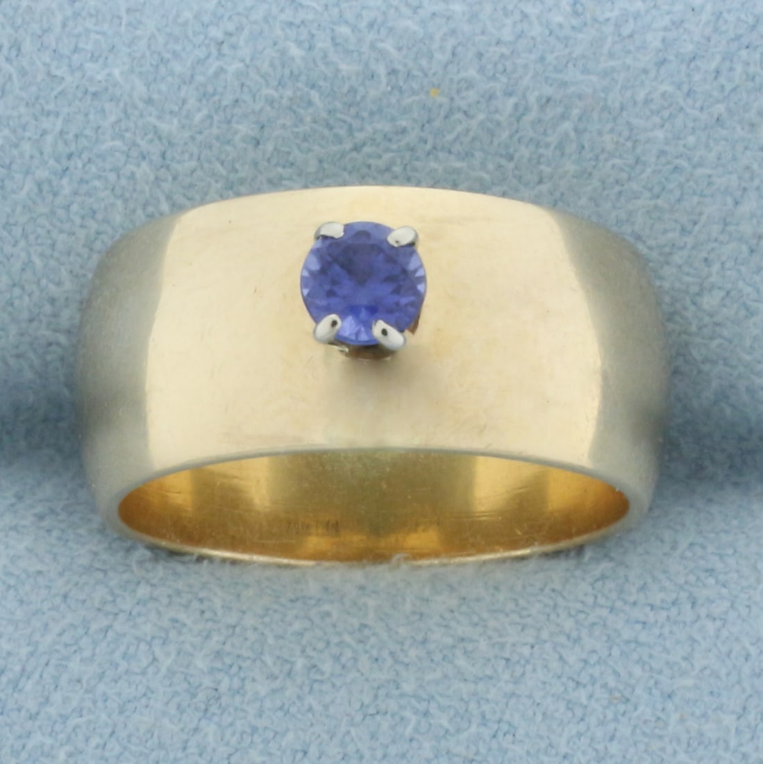 Sapphire Solitaire Wide Band Ring in 14k Yellow Gold: In 14k yellow gold. Contains one high quality natural 1/4ct sapphire gemstone with vibrant color and excellent clarity. 9mm wide cigar style band. Size 6.5. 8.6g.