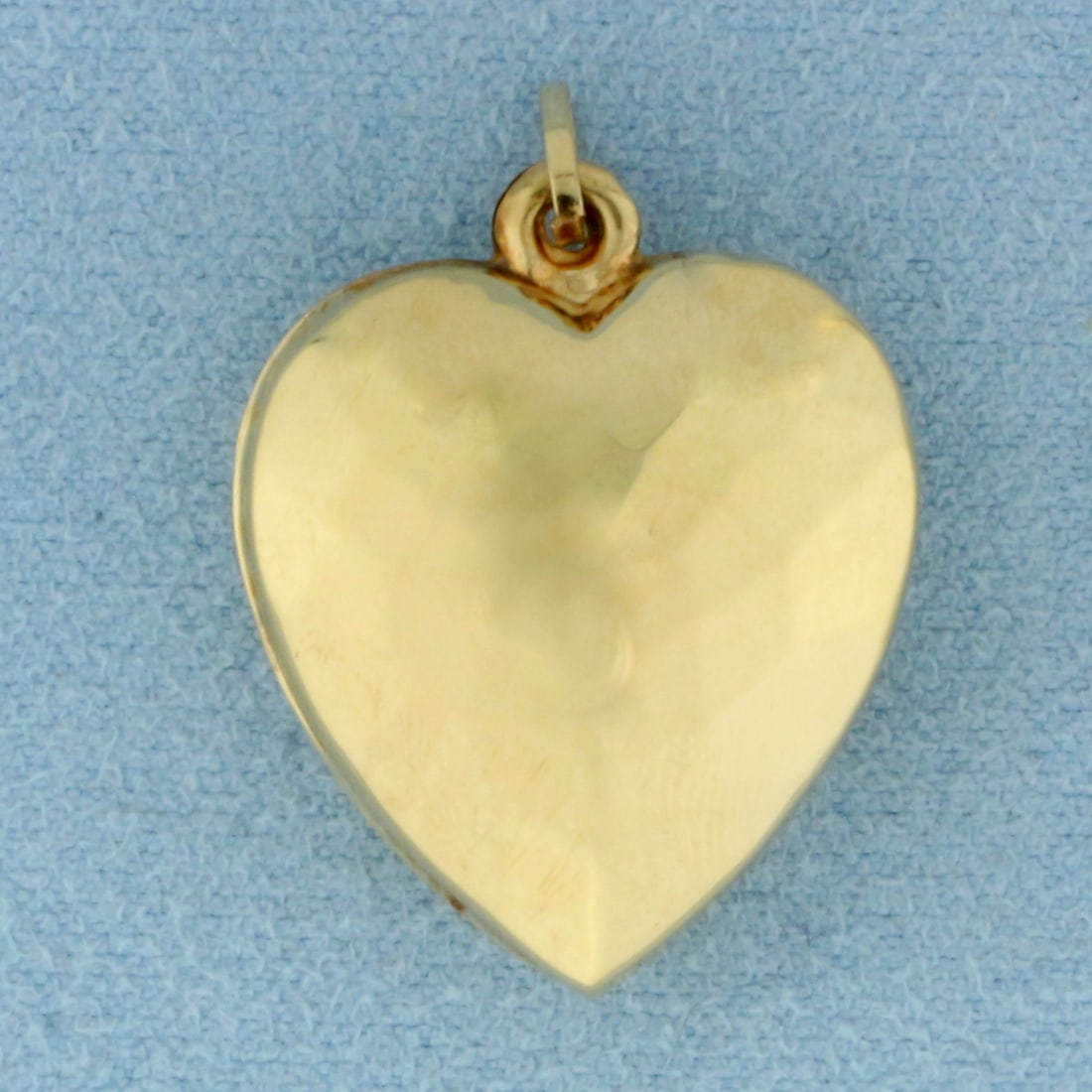 Puffy Heart Hammered Finish Pendant in 14k Yellow Gold: In 14k Yellow Gold. 1 inch long. 3/4 inch wide. Hammered finish for unique look. 1.6g.