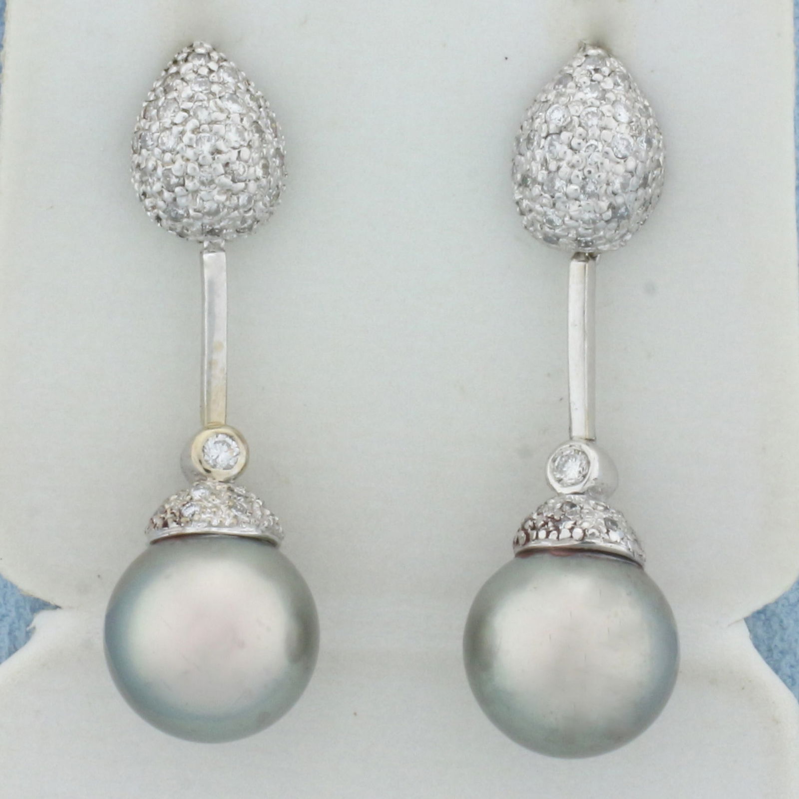 Tahitian Pearl and Pave Diamond Dangle Earrings in 18k White Gold: In 18k white gold. Contains two high quality natural 11mm Tahitian Pearls with high luster and beautiful silver color with peacock iridescent undertone. Also contains ninety-1/2pt and two .04ct high