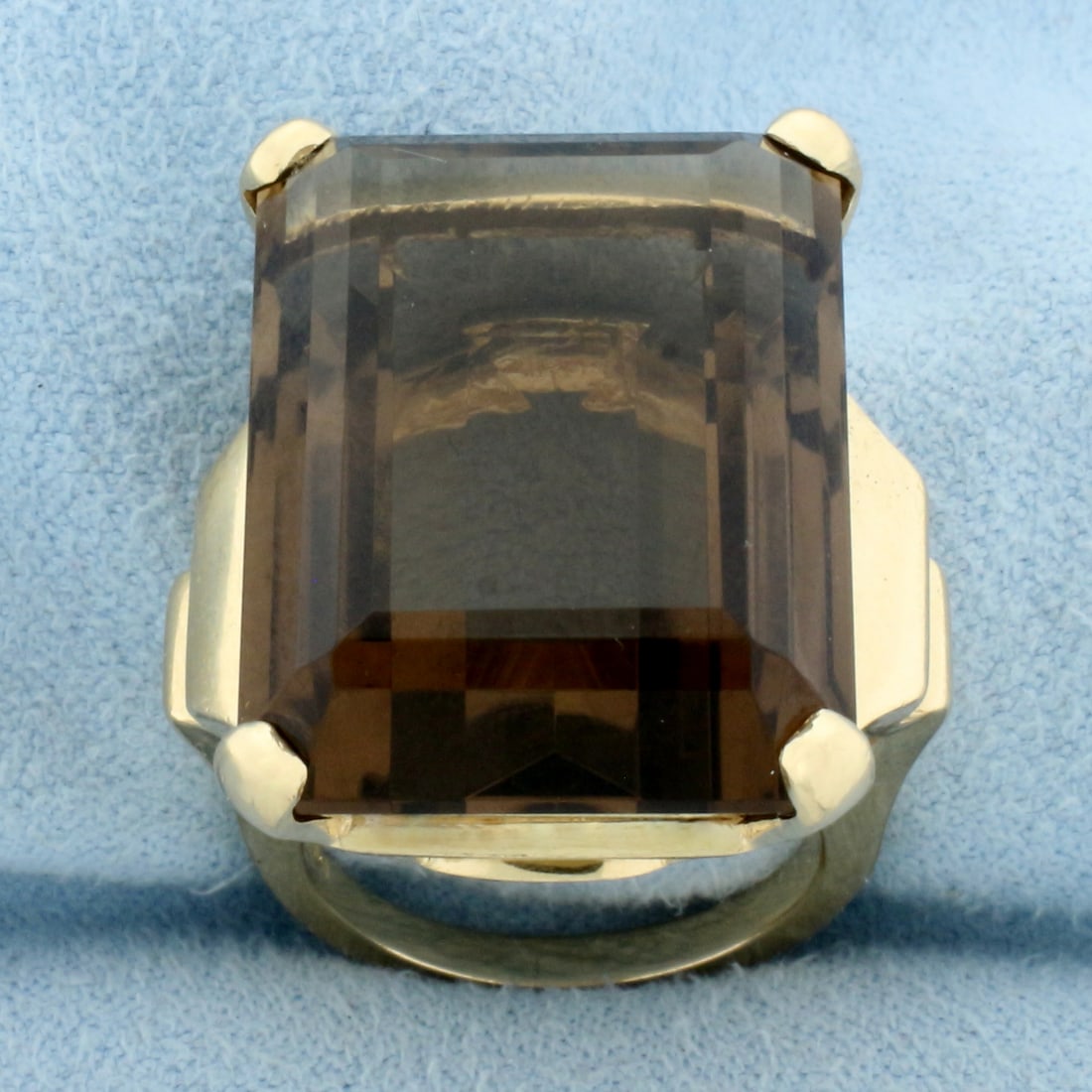 50ct Smoky Topaz Statement Ring in 14k Yellow Gold: In 14k Yellow Gold. Contains one natural high quality 25mmx18mm emerald cut smoky topaz gemstone, approximately 50ct, with intense color and excellent clarity. Size 5.75. 19.4g.
