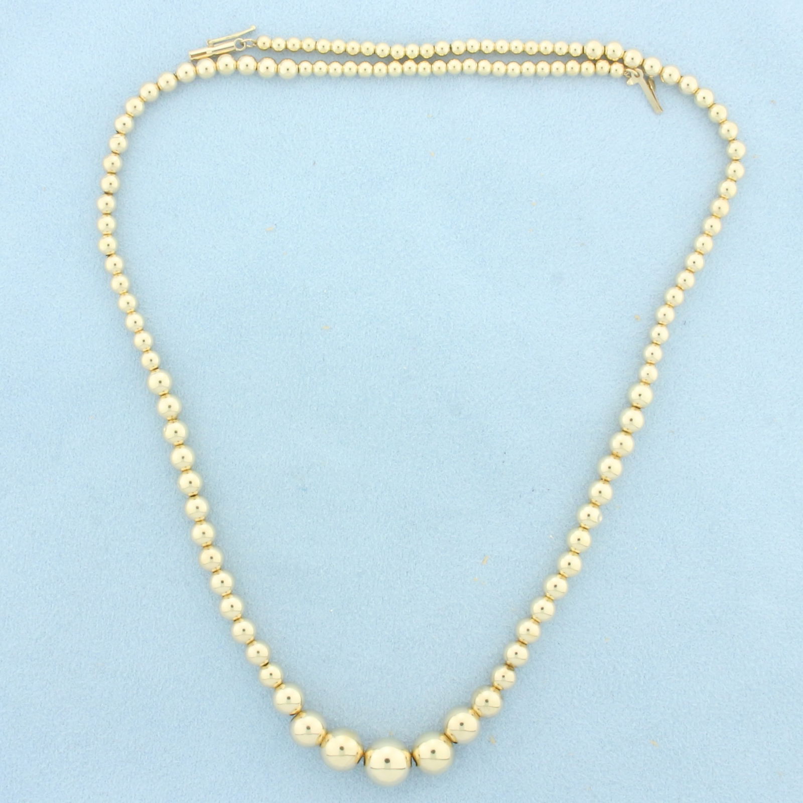 18 Inch Graduated Ball Bead Necklace in 14k Yellow Gold: In 14k Yellow Gold. 18 inches long. Beads 3-9mm. Barrel clasp with safety latch. 5.0g.