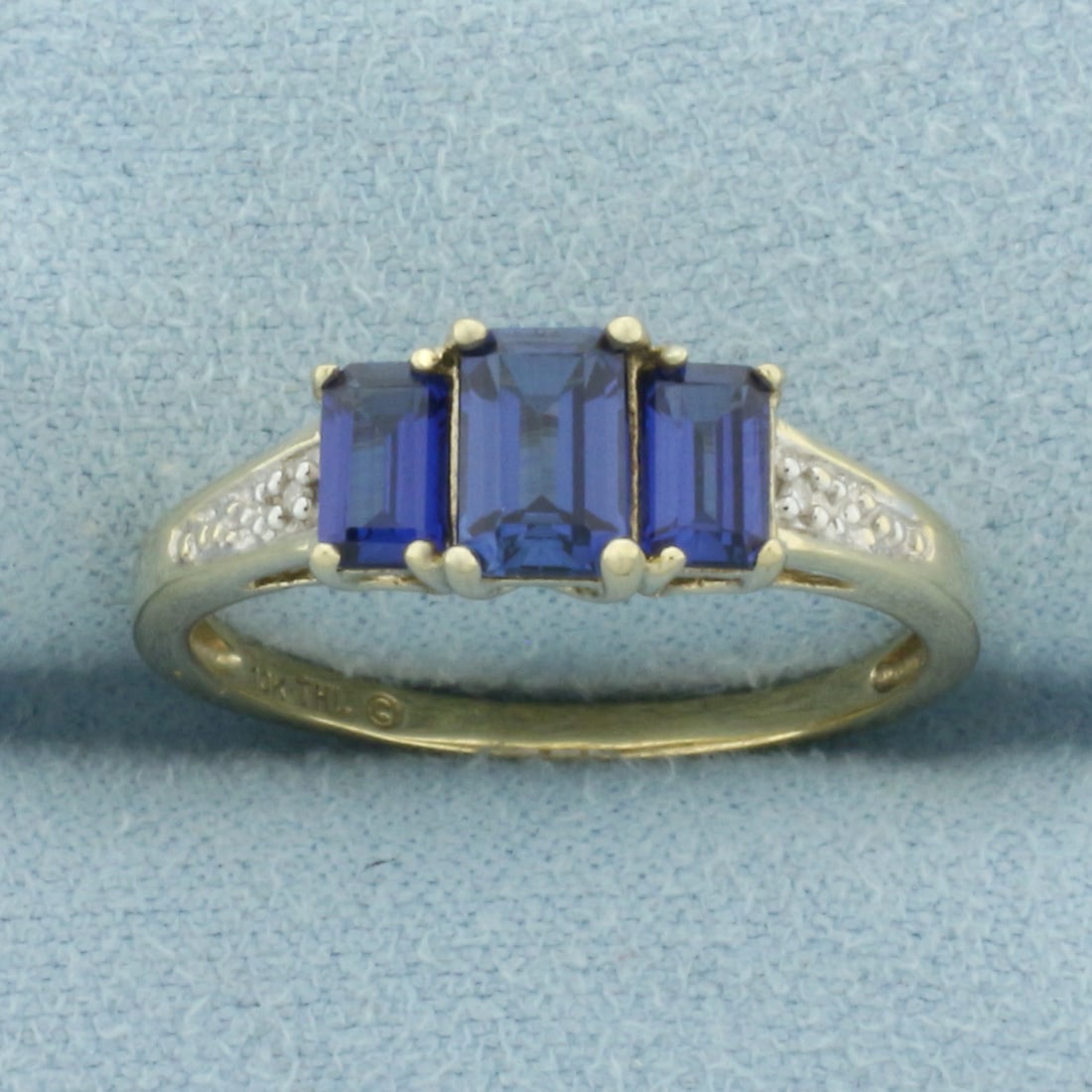 Lab Sapphire and Diamond Ring in 10k Yellow Gold: In 10k Yellow Gold. Contains one 6x4mm and two 5x3mm high quality emerald cut Lab Sapphire gemstones with vibrant color and excellent clarity. Also contains two high quality 1/2pt diamonds. Size 8.