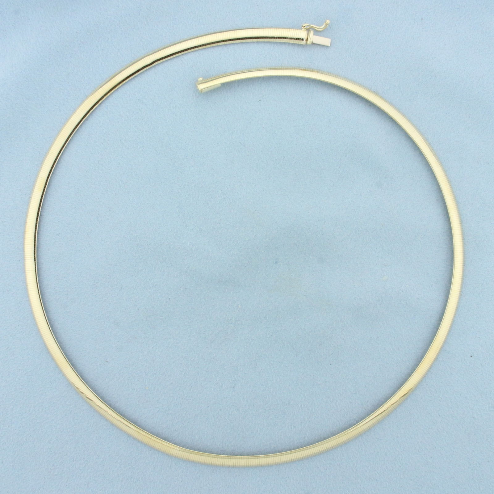 18 Inch Italian Omega Necklace in 14k Yellow Gold: In 14k Yellow Gold. 18 inches long. 5mm wide. Italian made. Slide clasp with safety latch. 13.8g.