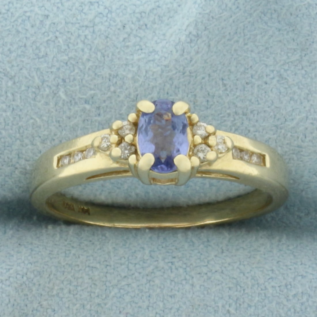 Tanzanite and Diamond Ring in 14k Yellow Gold: In 14k Yellow Gold. Contains one 6x4mm high quality natural Sapphire gemstone, approximately 1/2ct, with bright color and excellent clarity. Small chip on side of gemstone, not noticeable. Also