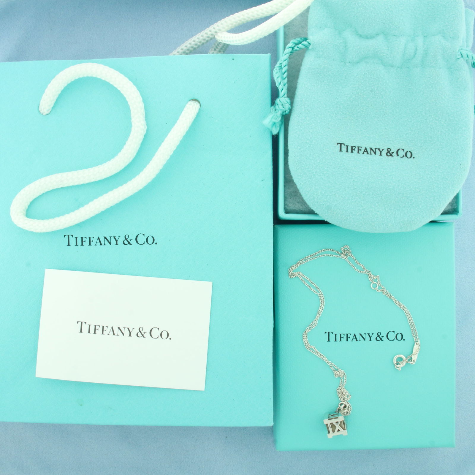 Tiffany & Co. Atlas Cube Sterling Silver Pendant on Chain: In .925 sterling silver. Guaranteed authentic Tiffany. Chain Adjustable 16" or 18" long with spring clasp. Pendant is 1/2 inch long. Includes pouch, box, bag, and care card.