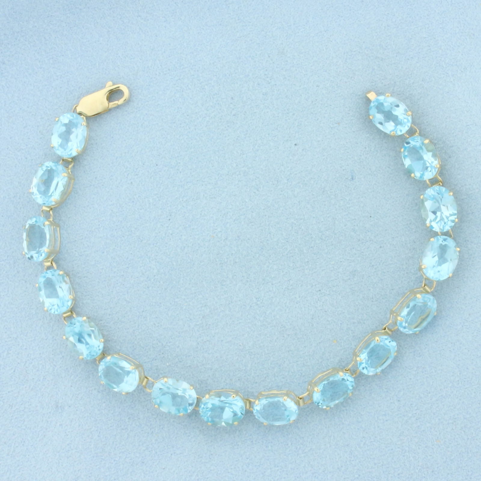 Sky Blue Topaz Tennis Bracelet in 14K Yellow Gold: In 14k yellow gold. Measures 7.5 inches long. Contains sixteen 9mm high quality natural Sky Blue Topaz gemstones, approximately 40ct TW, with bright color and excellent clarity. Lobster clasp. 12.1g