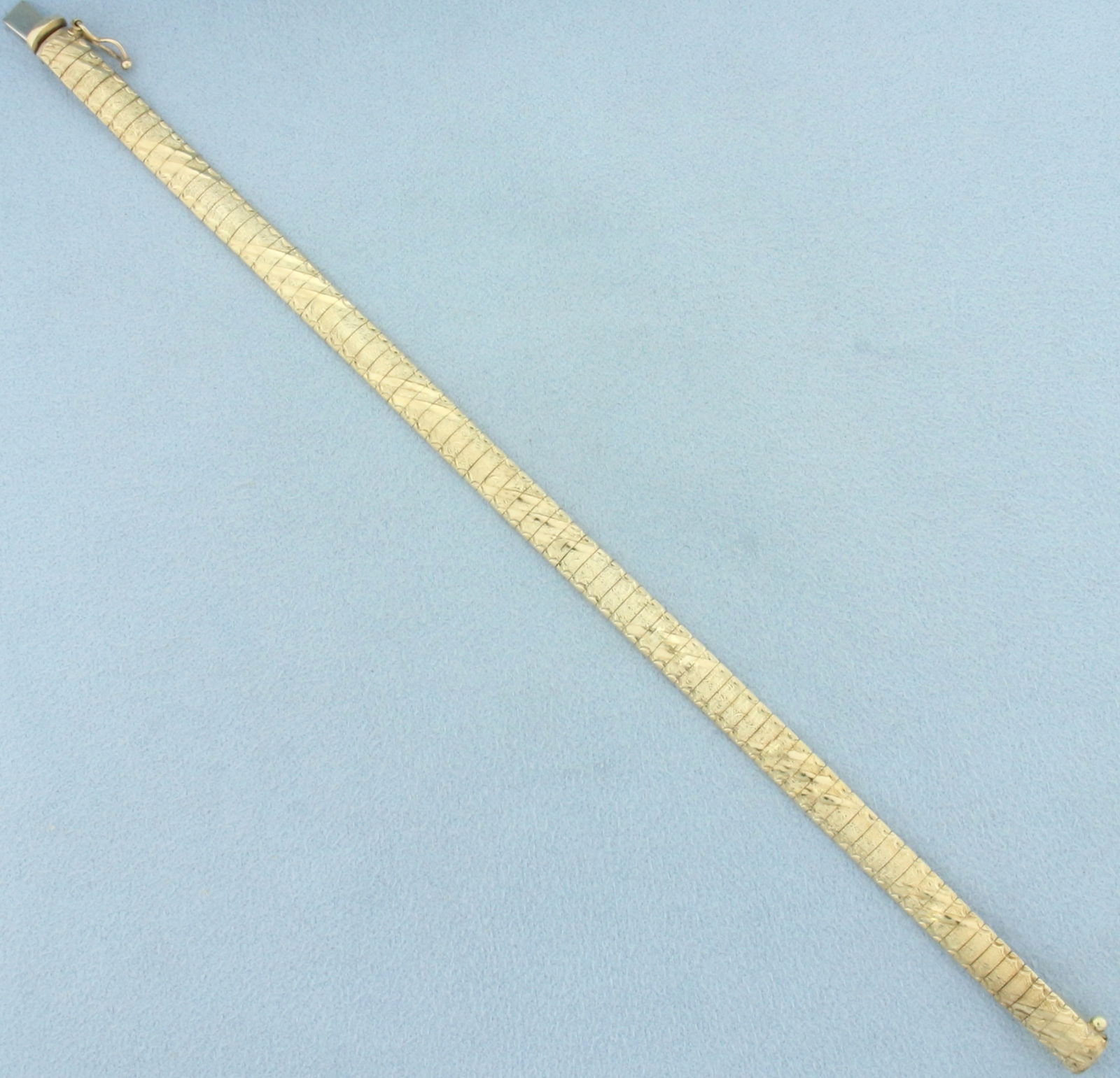 Italian Diamond Cut Sandblast Finish Omega Link Bracelet in 10k Yellow Gold: In 10k Italian made yellow gold. 7 1/8 inches long, 1/4 inch wide. Concealed slide clasp with safety latch. Unique sandblast finish and diamond cut design for unique look. 12.0g