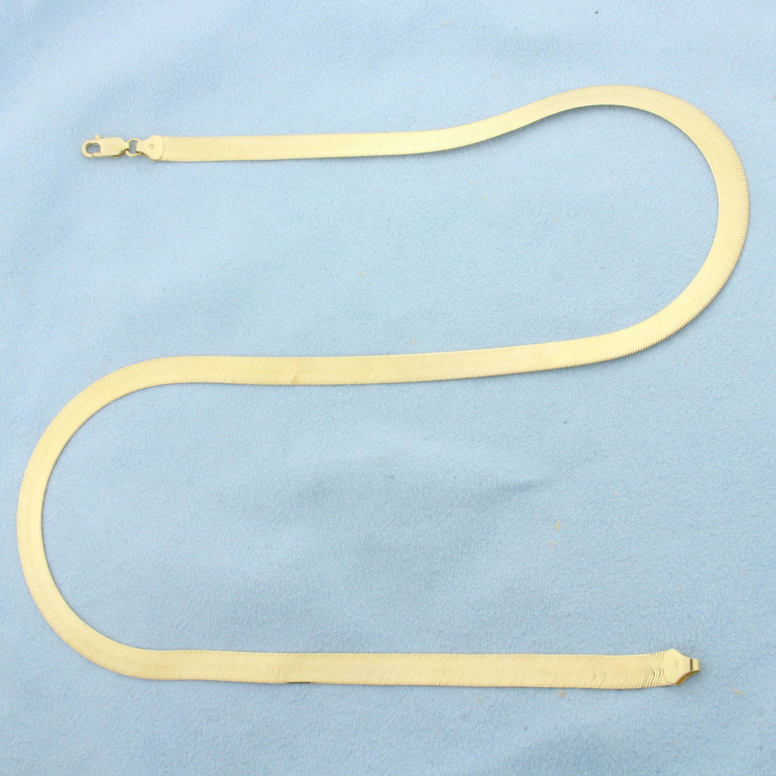 20 Inch Italian Liquid Gold Herringbone Chain Necklace in 14k Yellow Gold: In 14k Yellow Gold. 20 inches long. 6mm wide. Italian made. Lobster clasp. 12.5g.