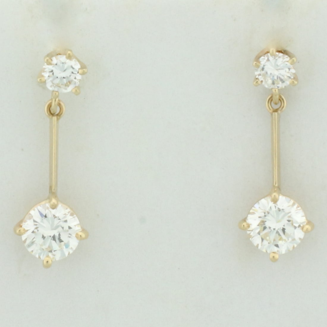 Diamond Dangle Earrings in 14k Yellow Gold: In 14k yellow gold. Contains two 2/3ct and two 1/5ct high quality round brilliant diamonds, VS clarity/I color, great cut for lots of sparkle. 7/8 inches long. Friction backs. 2.2g.