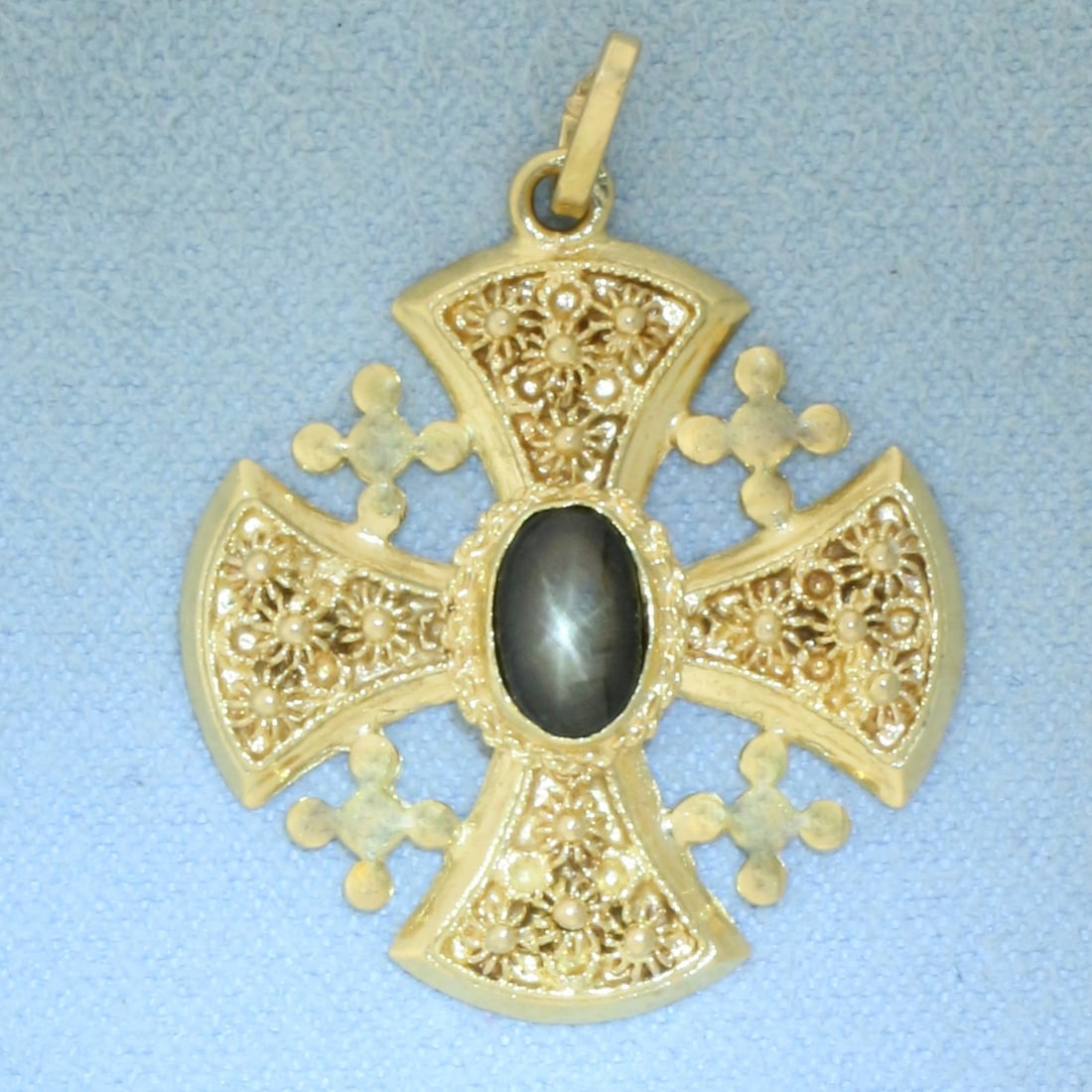 Natural Star Sapphire Jerusalem Cross Pendant in 18k Yellow Gold: In 18k yellow gold. Contains one high quality natural 8mm by 5mm black star sapphire with distinct "star" under light. 1 1/4 inches long (including bale) x 1 inch wide. 6.7g.