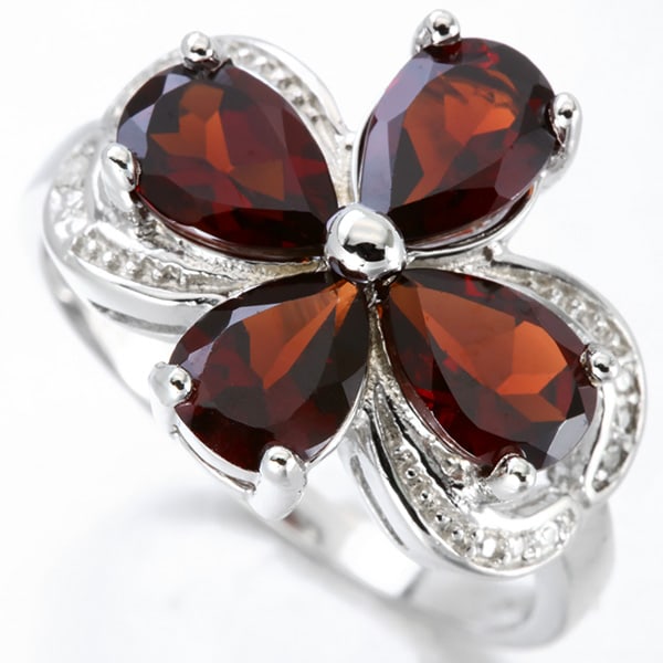 Garnet and Diamond Ring in Sterling Silver: In platinum over .925 sterling silver. Contains four pear cut garnet gemstones, 3.3ctw, accented with two diamonds, .01ctw. Size 7. 3.8g