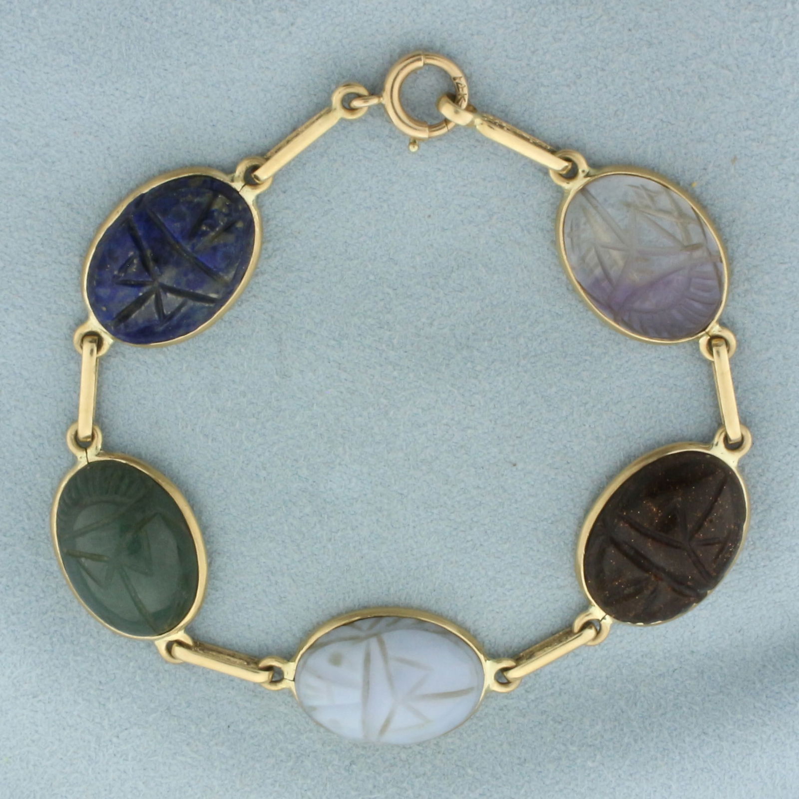 Hand Carved Gemstone Scarab Bracelet in 14k Yellow Gold: In 14k yellow gold. Contains five high quality 18 by 13mm gemstones including lapis lazuli, jade, chalcedony, quartz, and moonstone. 7 1/4 inches long and 1/2 inches wide. Spring clasp. 16.4g.