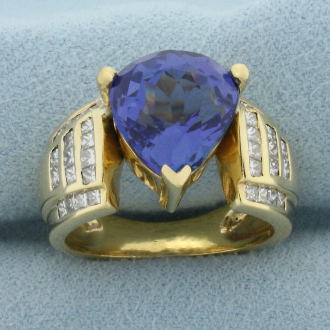 AAA Tanzanite and Diamond Ring in 18k Yellow Gold: In 18k Yellow Gold. Contains one high quality 8ct AAA quality Tanzanite gemstone with ultra intense color and excellent clarity. Also contains thirty-four 2mm princess cut diamonds, VS clarity/G color