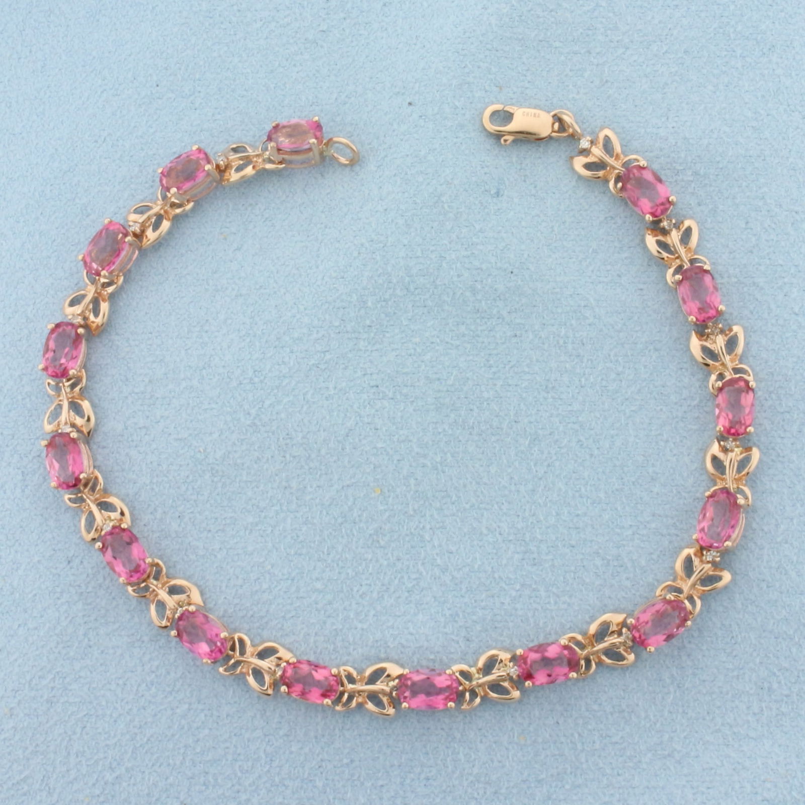 Pink Topaz and Diamond Tennis Bracelet in 10K Rose Gold: In 10k rose gold. Measures 7.5 inches long. Contains 15 high quality natural 6mm Pink Topaz gemstones, approximately 7.5ct TW, with bright color and excellent clarity. Also contains 15 high quality