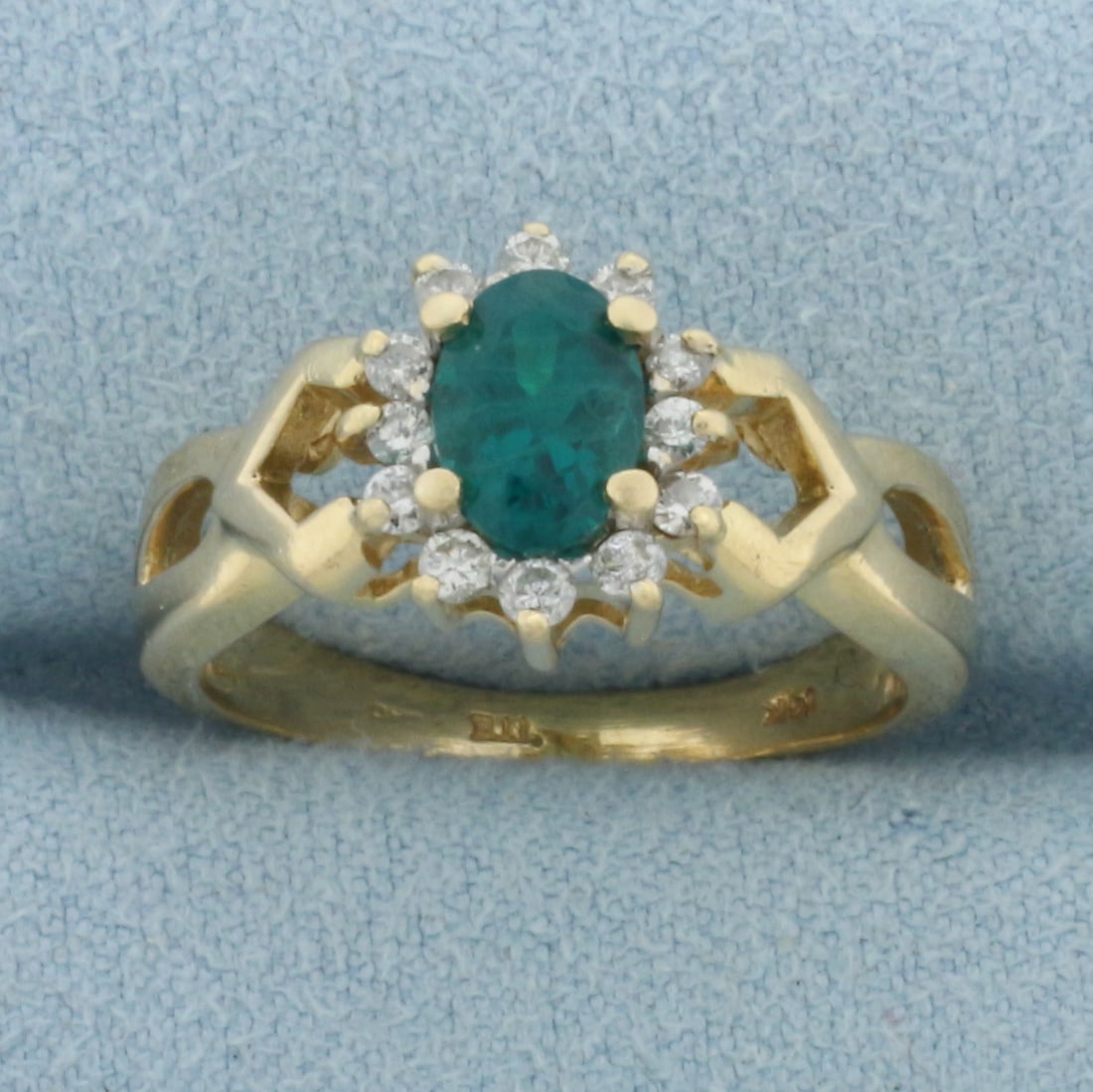 Emerald and Diamond Halo Ring in 14k Yellow Gold: In 14k Yellow Gold. Contains one 5x7mm high quality natural Emerald gemstone with vibrant color. Also contains twelve .01ct high quality diamonds. 10.6mm wide at top of ring. Size 7.5. 3.9g.