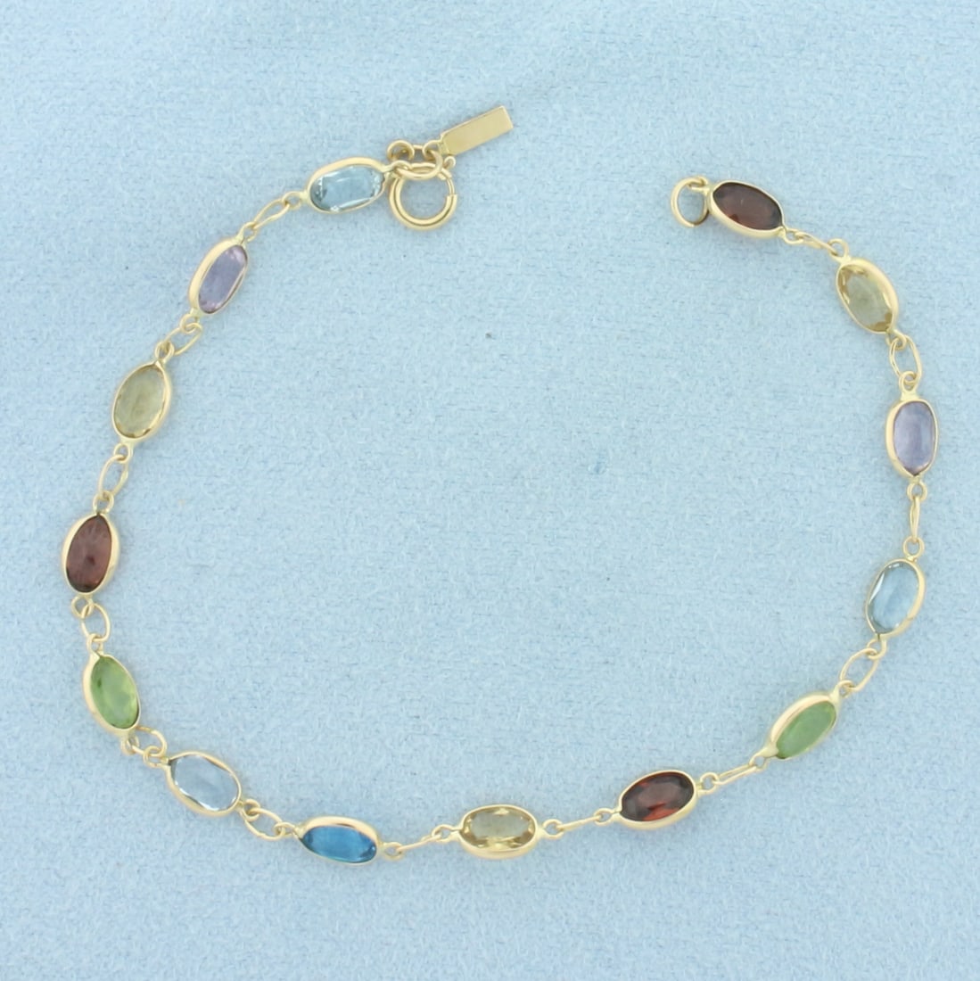 Rainbow Gemstone Bezel Set Link Bracelet in 14K Yellow Gold: In 14k yellow gold. Measures 7.25 inches long. Contains 14 high quality natural 6mm gemstones including: blue topaz, amethyst, citrine, carnet, and peridot. Approximately 7ct TW. All gems have