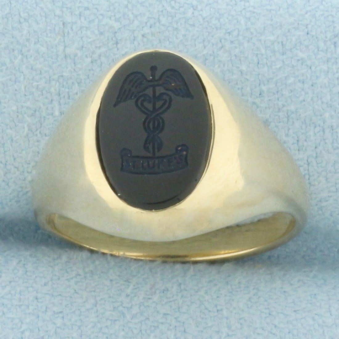 St. Luke's Caduceus Medical Symbol Onyx Signet Ring in 10k Yellow Gold: In 10k Yellow Gold. 12mm carved Onyx gemstone. Engraved initials "BJR" inside shank. Size 7.25. 7.1g.