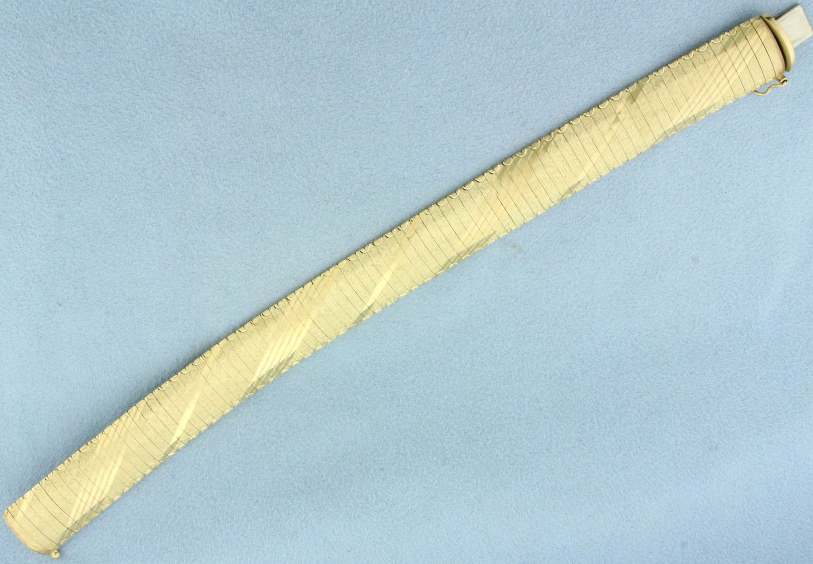 Italian Diamond Etched Omega Link Bracelet in 14k Yellow Gold: In 14k yellow gold.7 1/8 inches long. 5/8 inch wide. Safety clasp. 25.4g.