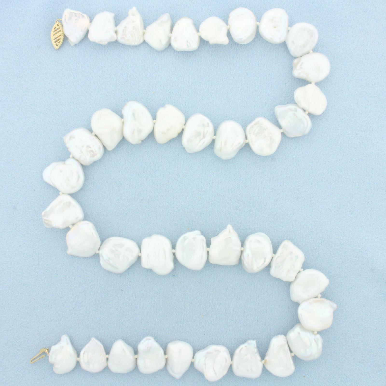 Baroque Pearl Strand Necklace: 14k Yellow Gold Clasp. Contains 39 Baroque Freshwater Pearls, 17mm each, with excellent iridescent shine and high luster. 20 inches long. Hand knotted. Decorative filigree clasp.