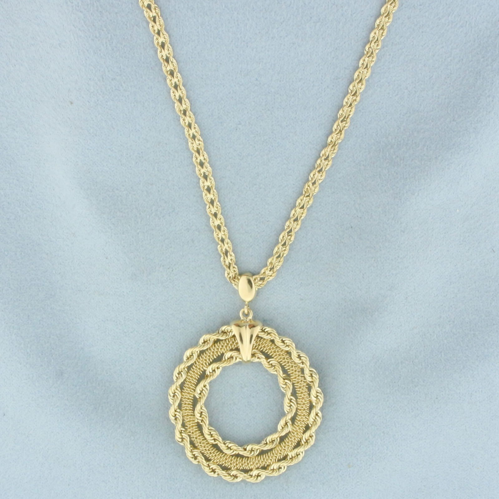 Rope Circle Medallion Necklace in 14k Yellow Gold: In 14k Yellow Gold. Rope chain is 17 1/2 inches long, 3mm wide. Pendant is 1 3/4 by 1 1/4 inch. Lobster clasp. 6.9g.