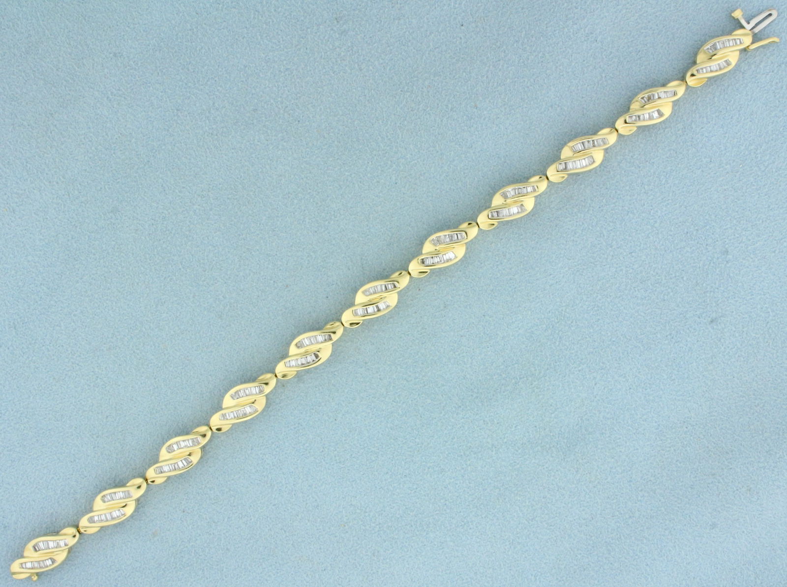 Baguette Diamond Tennis Bracelet in 14K Yellow Gold: In 14K Yellow Gold. Contains one hundred fifty four high quality baguette Diamonds, 2ct TW, SI clarity/H color. 7 1/4 inches long. 7.2mm wide. 23.0g