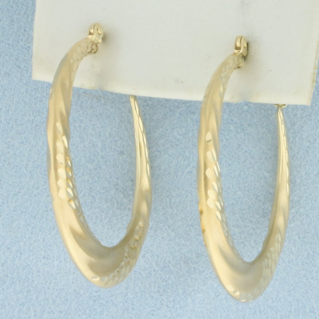 Satin and High Polish Hoop Earrings in 14k Yellow Gold: In 14k Yellow Gold. 1 1/2 inches long. Diamond cut high polish and satin finish. Leverback. 3.0g.