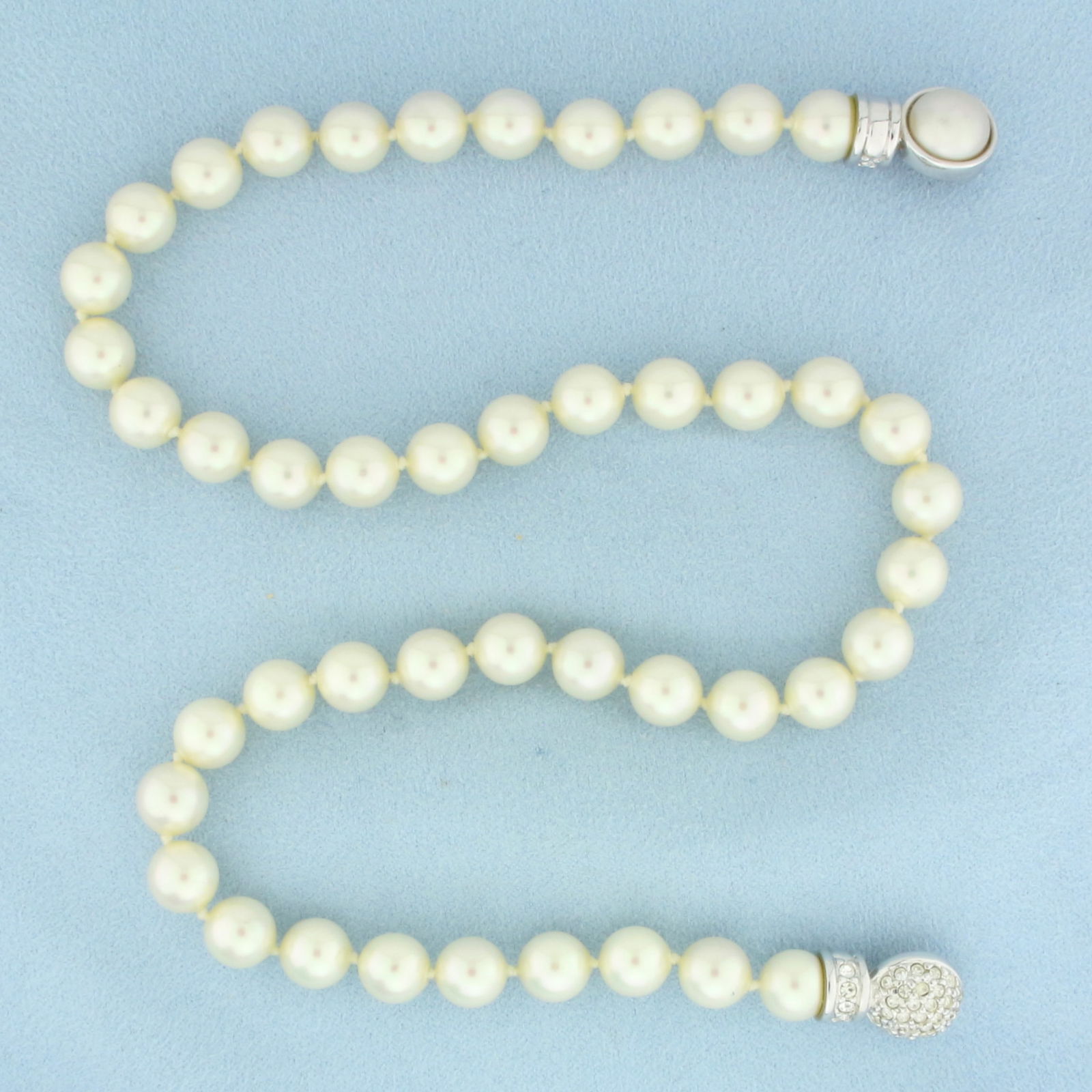 Christian Dior Faux Pearl and Rhinestone Necklace: 17 inches long. 8.2mm wide. Hand knotted. Reversible clasp with pearl on one side and rhinestones on other. Snap closure.
