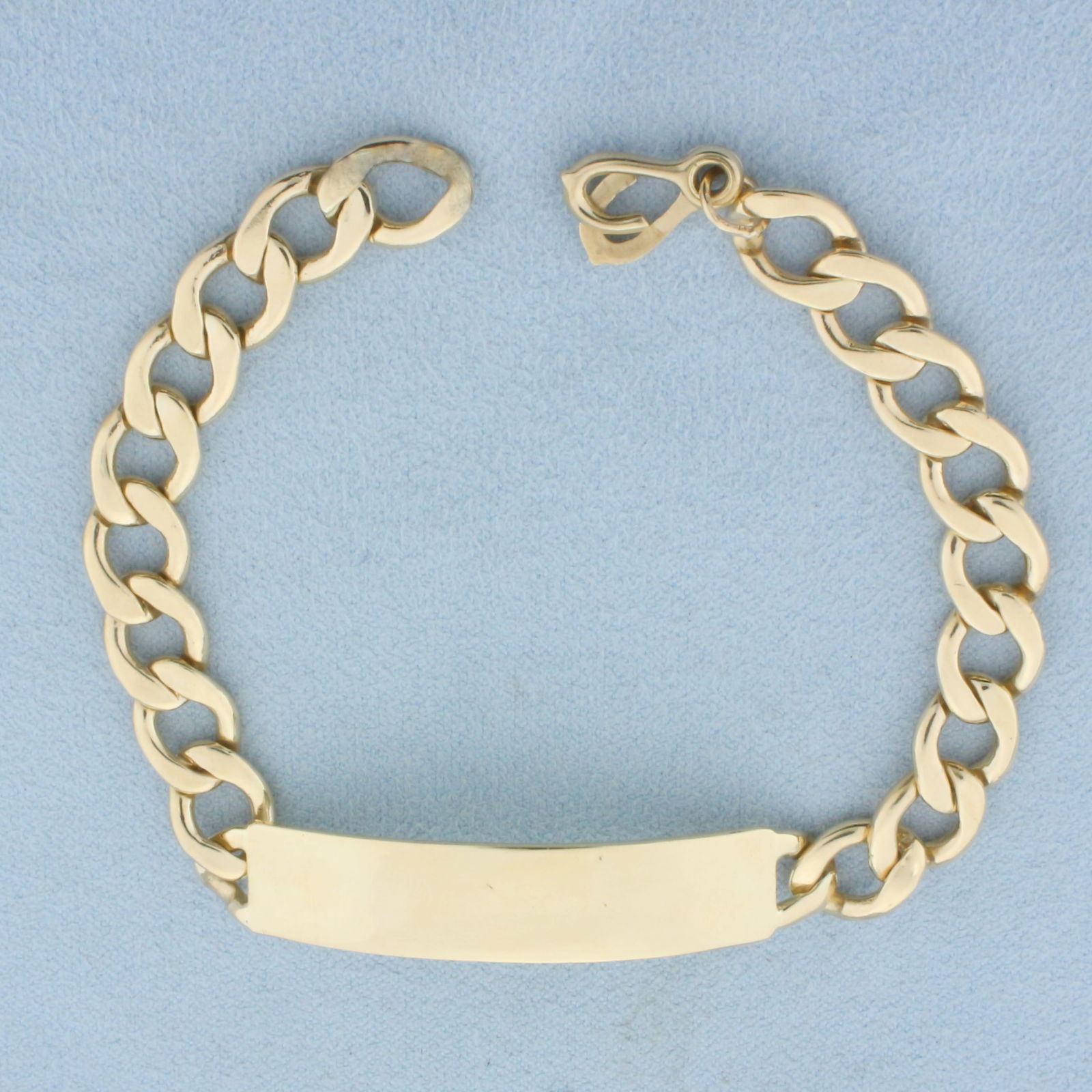 ID Bracelet Curb Link in 14k Yellow Gold: In 14k Yellow Gold. 8 inches long. 3/8 inch wide at nameplate. ID plate 2 inches long. Engravable. Hinged loop closure. 24.2g.