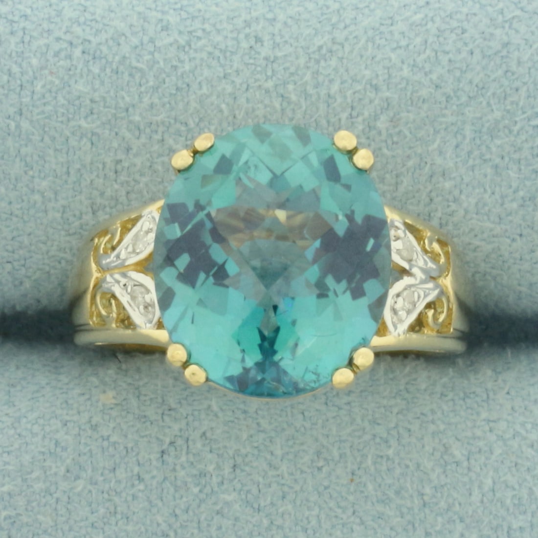 Teal Topaz and Diamond Ring in 10k Yellow Gold: In 10k Yellow Gold. Contains on 14mm high quality fancy checkerboard cut Teal Topaz gemstone, approximately 8cts, with vibrant color and excellent clarity. Also contains four high quality 1/2pt diamon