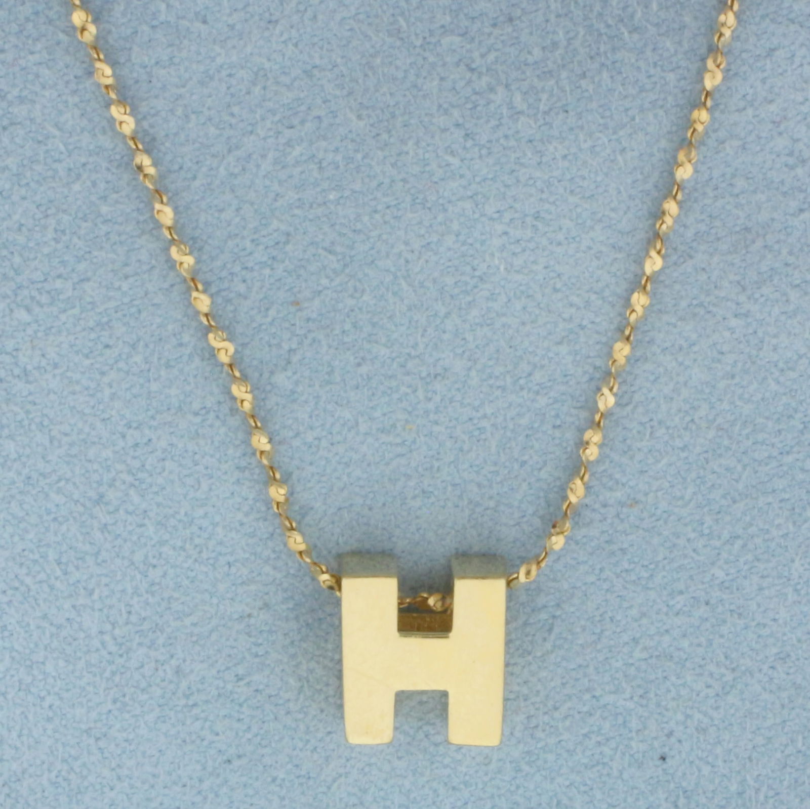 H Initial Necklace in 14k Yellow Gold: In 14k Yellow Gold. 3/8 inch by 3/8 inch pendant. 18 inch twisting S-Link chain, 1mm thick. Spring clasp. 3.8g.