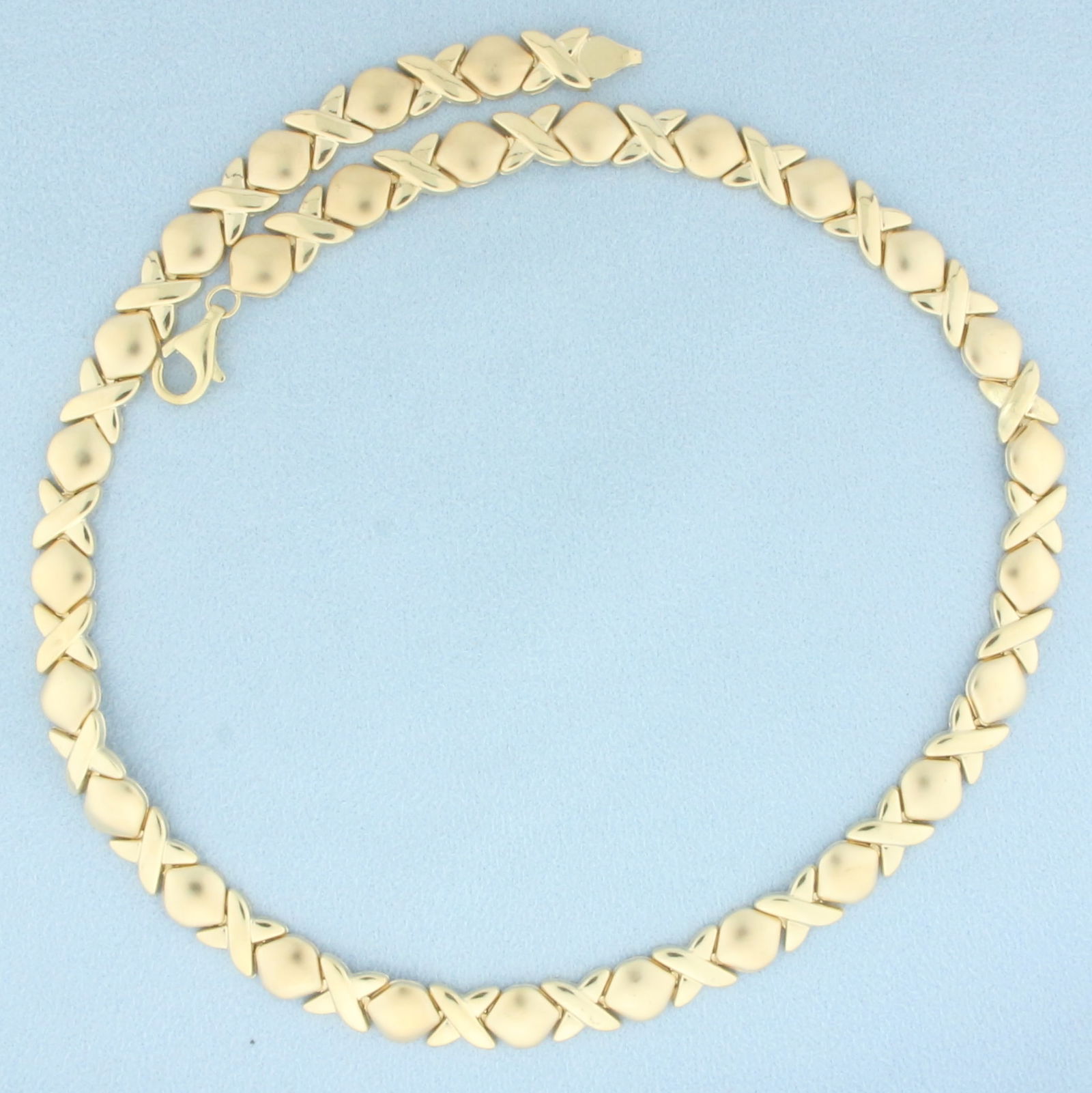 Satin and High Gloss Finish X and O Necklace in 10k Yellow Gold: In 10k yellow gold. 16 3/4 inches long and 1/4 inch wide. X's are satin finish, X's are high gloss finish. Lobster clasp. 13.5g.