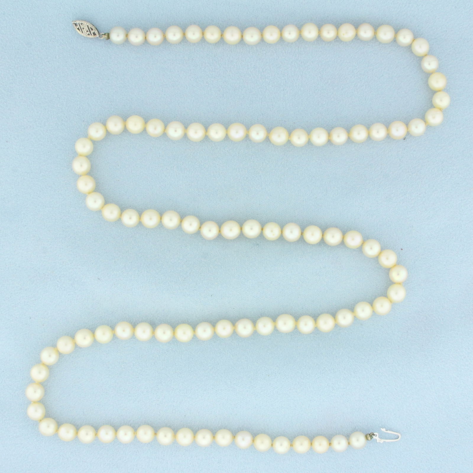 Cultured Akoya Pearl Strand Necklace in 10k White Gold: In 10k white gold. Contains 6.5mm Cultured Akoya pearls with high luster. Hand knotted. 27 inches long. Decorative filigree locking clasp. 35.2g.