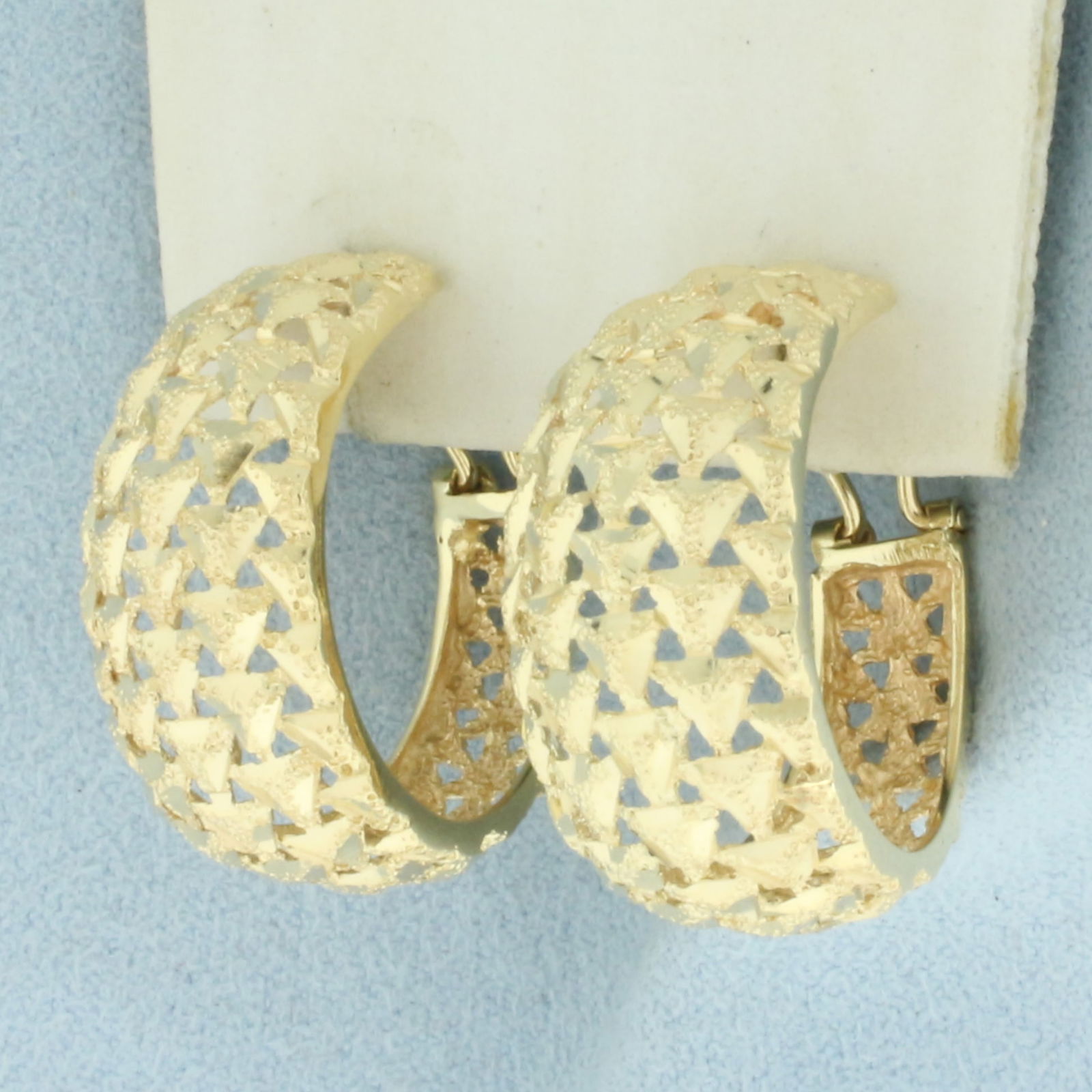 Woven Design Hoop Earrings in 14k Yellow Gold: In 14k Yellow Gold. 1 inch long. 3/4 inch wide. 13mm wide from front. Diamond cut detailing. For Pierced ears. Omega backs. 7.4g.