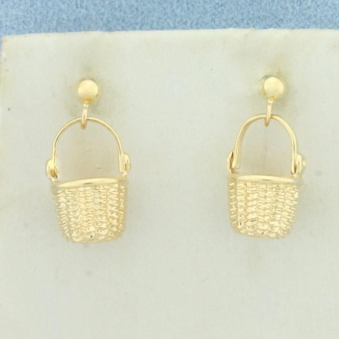 Wicker Basket Dangle Earrings in 14k Yellow Gold: In 14k Yellow Gold. 5/8 inch long. 3/8 inch wide. Friction backs. 3.4g.