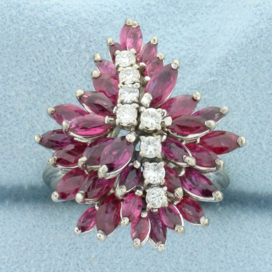 Vintage Ruby And Diamond Flower Design Ring in 18k White Gold: In 18k white gold. Contains thirty two high quality natural marquise shaped Ruby gemstones with vibrant color and excellent clarity, 3mm to 6mm each, perfectly matching. Also contains eight .04ct high