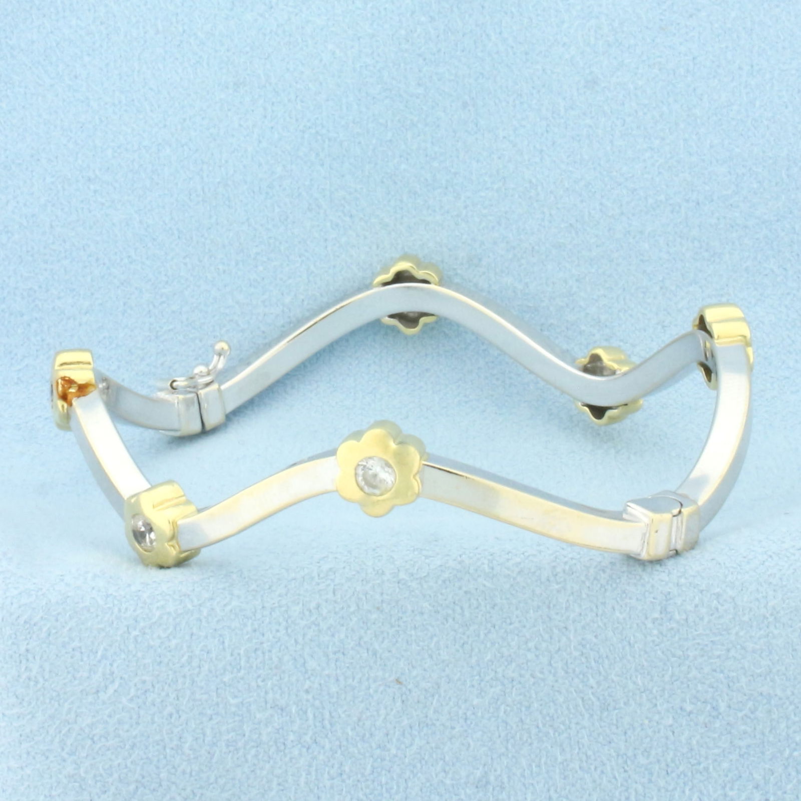 Flower Station Bangle Bracelet in 18k White and Yellow Gold: In 18k white and yellow gold. Italian made. Contains six high quality .15ct CZ gemstones with excellent clarity and cut for added brilliance. Interior dimensions 2 1/4 inches by 2 inches. Unique wave