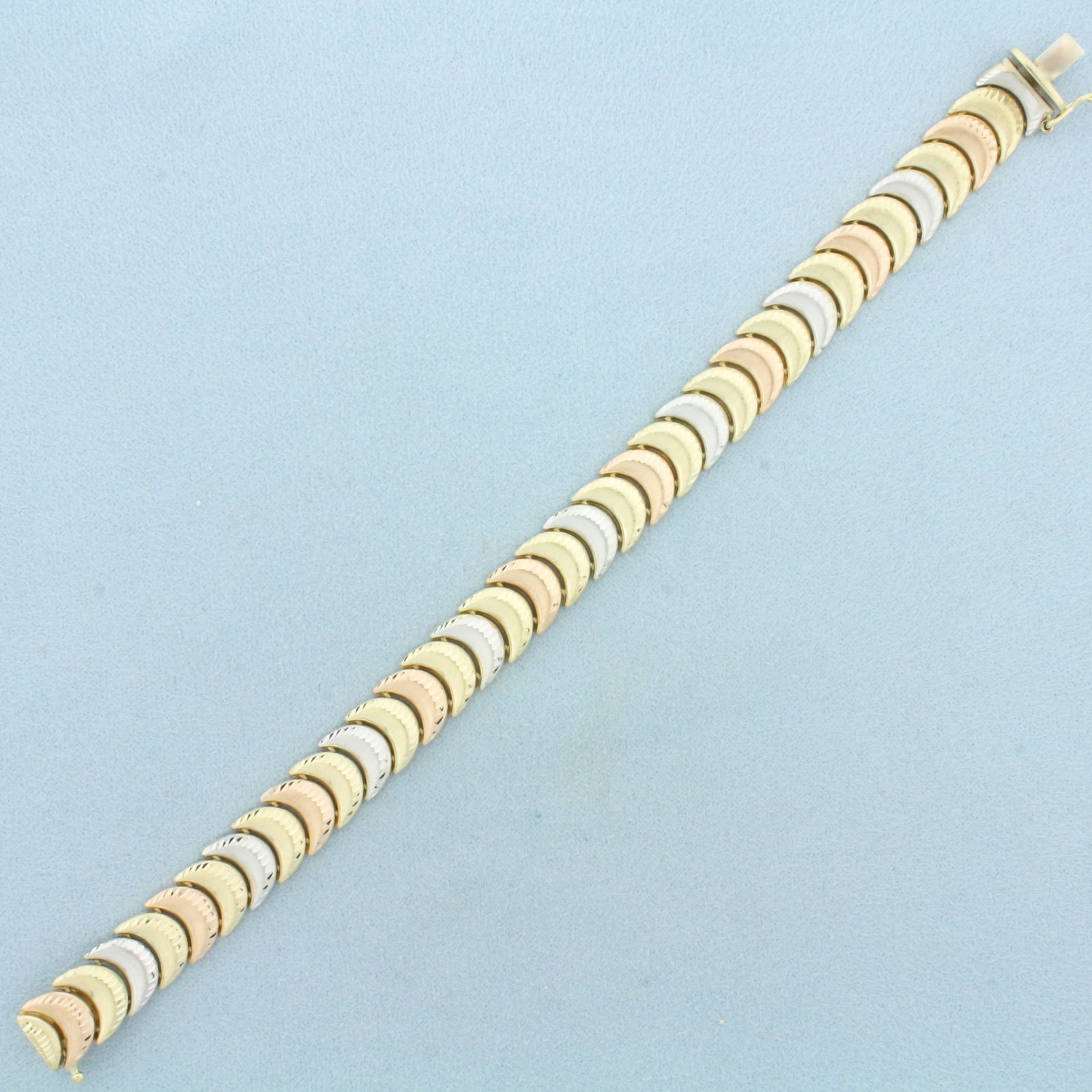 Designer Crescent Link Bracelet in 10k Yellow, White, and Rose Gold: In 10k Yellow, White, and Rose Gold. 7 inches long. 3/8 inch wide. Concealed slide clasp with safety latch. 13.0g.