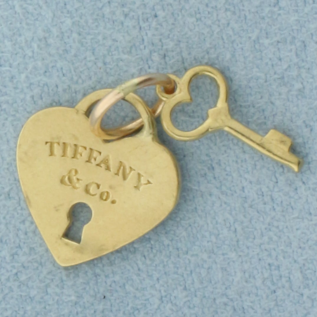 Tiffany & Co. Stamped Heart Lock and Key Charm in 18k Yellow Gold: In 18k Yellow Gold. 5/8 inch long. 1/2 inch wide (including jump ring). Stamped "Tiffany and Co." 1.8g.