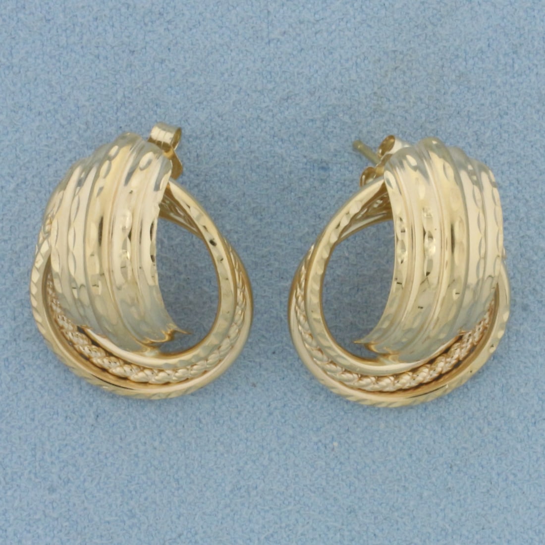 Diamond Cut Knot Design Earrings in 14k Yellow Gold: In 14k Yellow Gold. 7/8 inch long. 5/8 inch wide. Friction backs. 3.9g.