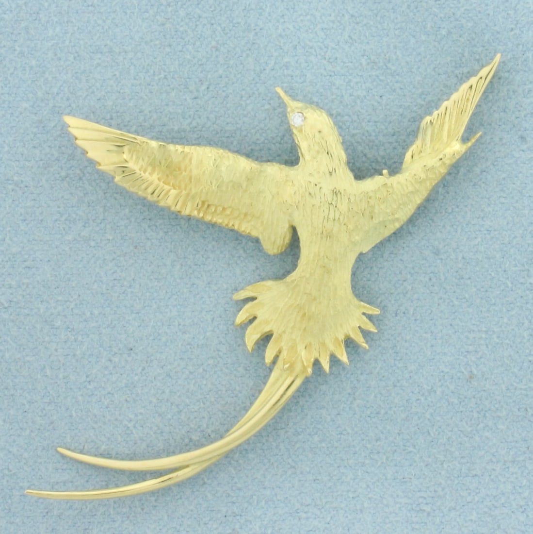 Diamond Longtail Bird Brooch in 18k Yellow Gold: In 18k Yellow Gold. Contains one .01ct high quality diamond as an eye. 2 inch wide. 1 3/8 inch long. 6.4g.