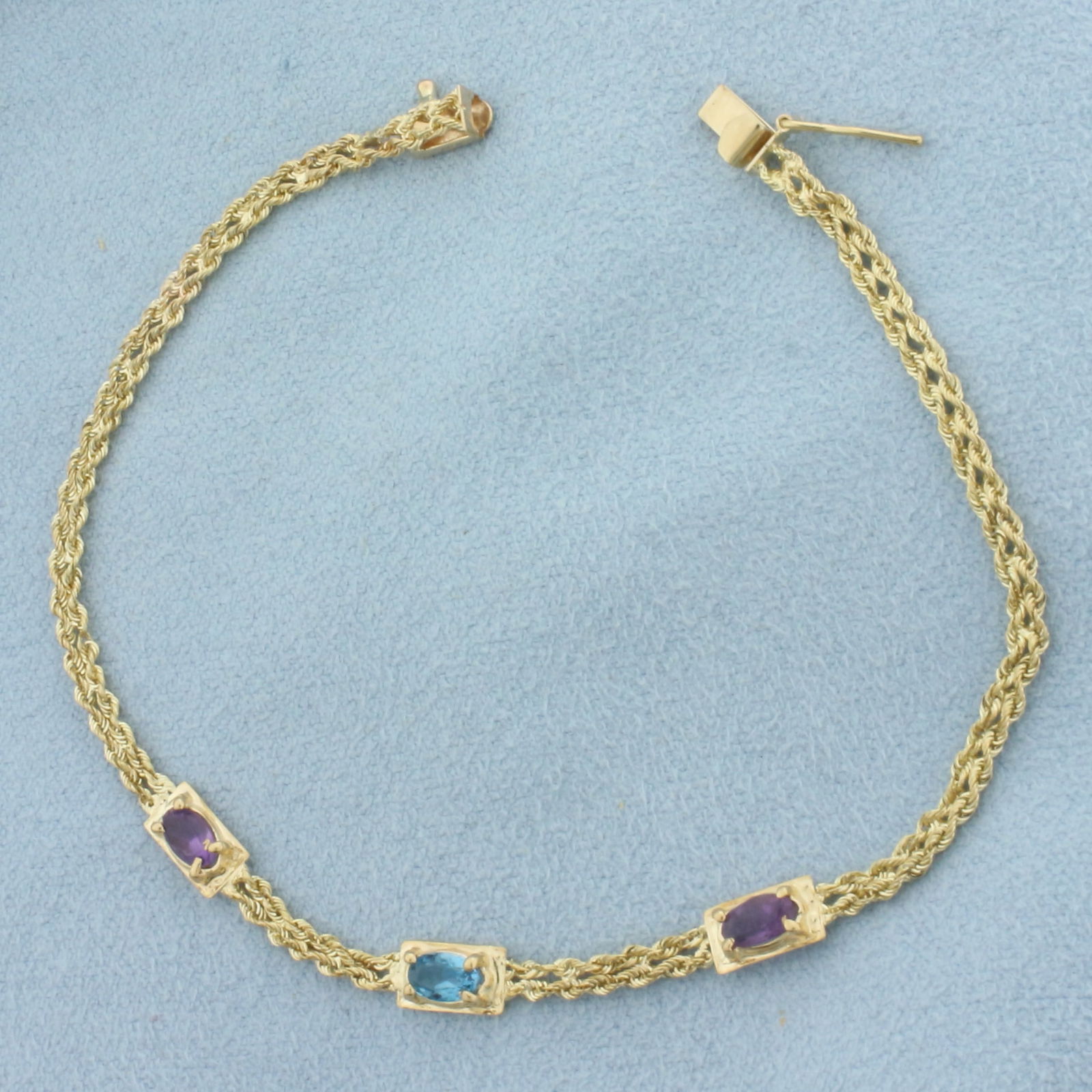 Amethyst and Blue Topaz Bracelet in 14k Yellow Gold: In 14k Yellow Gold. Contains two 5mm Amethyst and one 5mm Blue Topaz high quality natural gemstones with vibrant color and excellent clarity. 7 inches long, 2.4mm wide double rope link chain. Slide cl