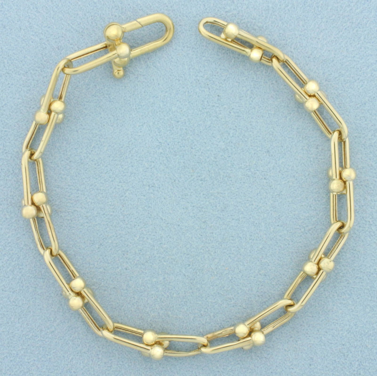 Hardware U Link Bracelet in 18k Yellow Gold: In 18k Yellow Gold. 7 1/8 inches long. 1/4 inch wide. Decorative spring clasp. 8.2g.