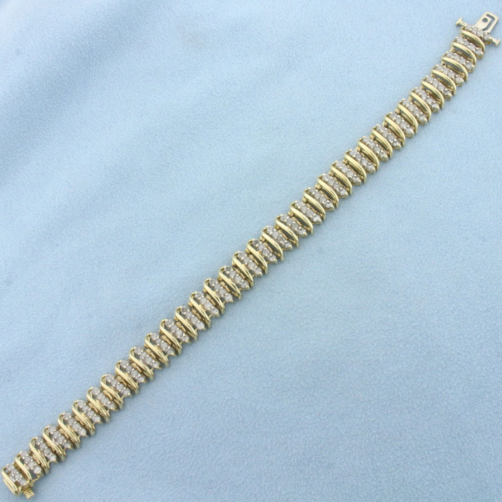 5ct Diamond Bracelet in 14k Yellow Gold: In 14k Yellow Gold. Contains one hundred and forty high quality diamonds, 5ct TW, I color/I clarity. 7 3/8 inch long. 3/8 inch wide. Concealed side clasp with underswing safety latch.