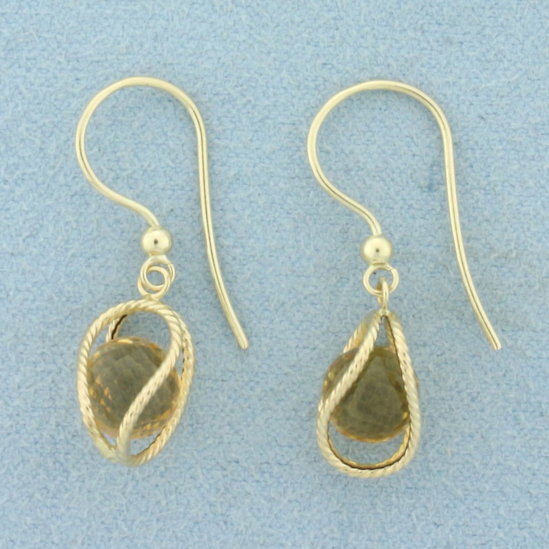 Disco Citrine Cage Dangle Earrings in 14k Yellow Gold: In 14k Yellow Gold. Contains two high quality natural 6.8mm sphere faceted Citrine gemstones with vibrant color and excellent clarity. 1 inch long. 1/4 inch wide at widest. Shepherds hook closure. 1.9