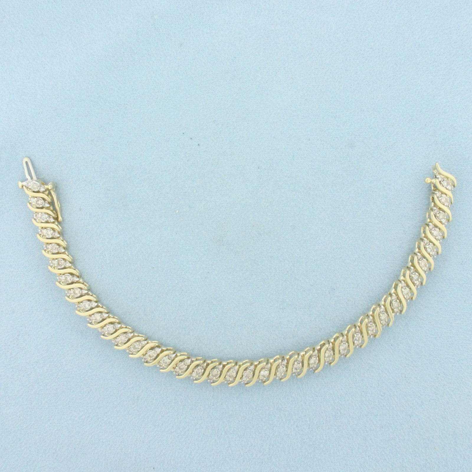 Diamond S-Link Tennis Bracelet in 10k Yellow Gold: In 10k Yellow Gold. Contains one hundred and fourteen high quality diamonds, 3ct TW, I color/I clarity. 7 1/8 inches long. 7mm wide. Concealed slide clasp with safety latch. 17.8g.