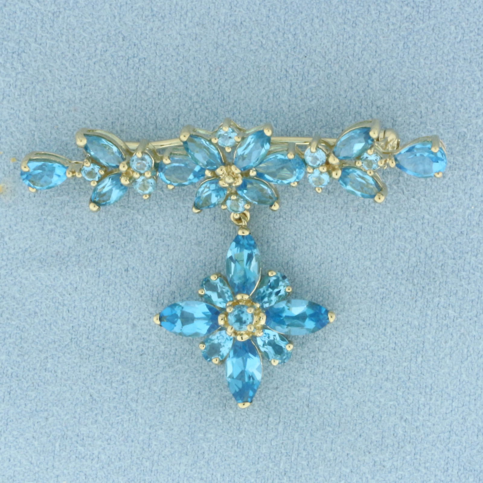 Blue Topaz Flower Dangle Brooch Pin in 10k Yellow Gold: In 10k Yellow Gold. Contains four 4x8mm and eight 3x6mm marquise, four 4x6mm and four 3x6mm pear cut, and eight 2mm and one 3mm round high quality natural Swiss Blue Topaz gemstones, approximately 8.5