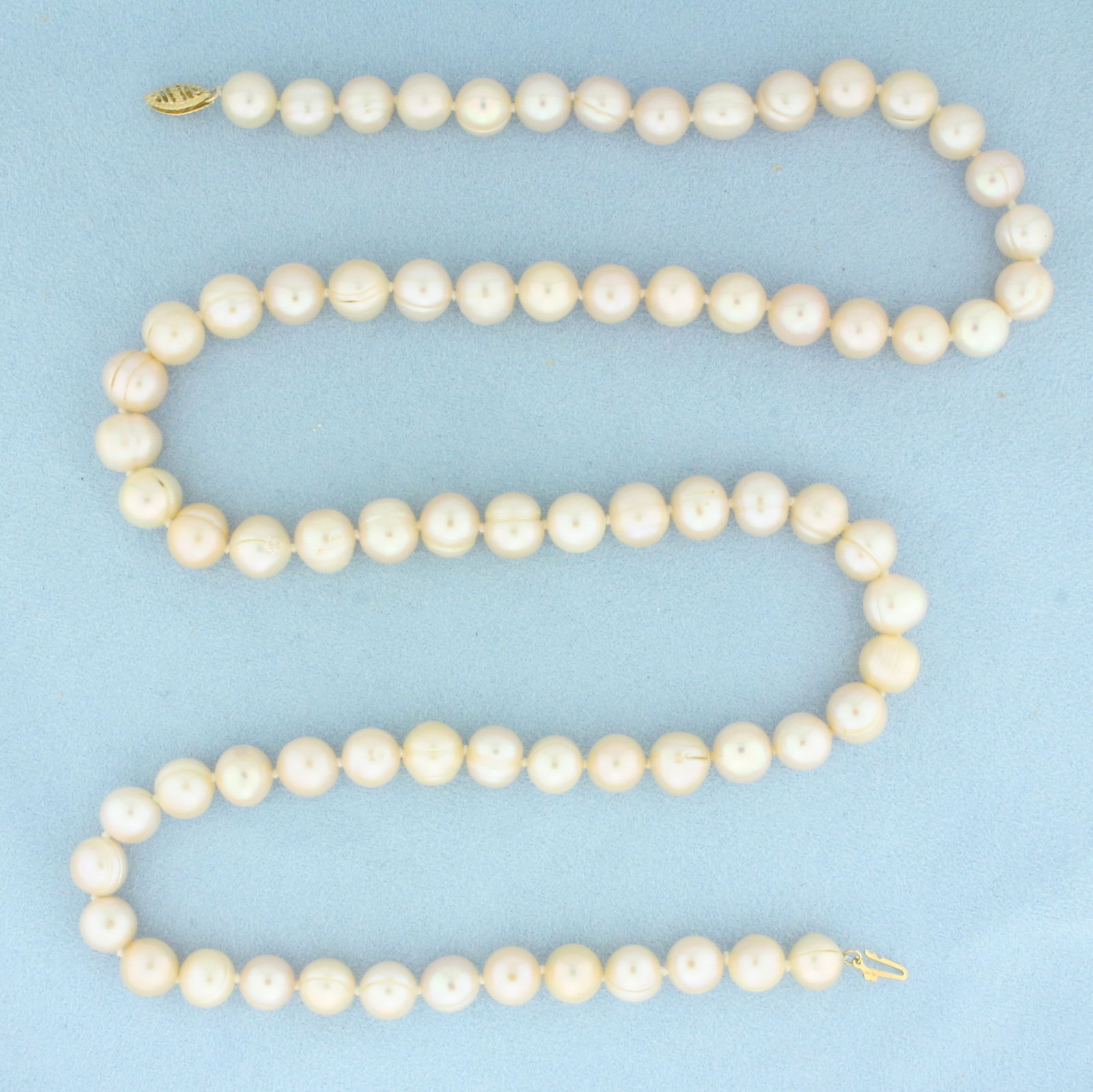 Cultured Akoya Pearl Baroque Pink Tone Strand Necklace in 14k Yellow Gold: 14k Yellow Gold Clasp. Contains 9mm high quality Cultured Akoya Baroque Pearls with pink undertones and high luster. 28 inches long. Hand knotted. Decorative filigree clasp. 76.7g.
